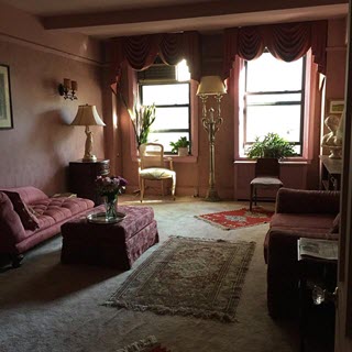 Pastel dusty rose-silk covered chaise lounge on plush pale pink carpeting, wine floor to ceiling drapes, like the salon of a French country home