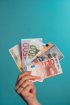 Hand holding paper cash of various nations